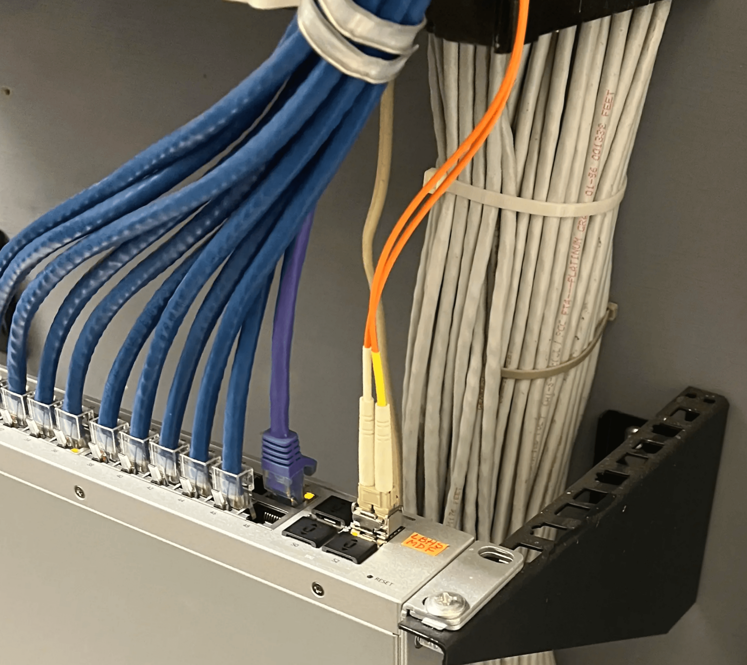 Neatly organized low voltage data cabling in a network panel with Ethernet cables and patch panels, highlighting the structured and professional wiring services provided by Axe Fire & Security.