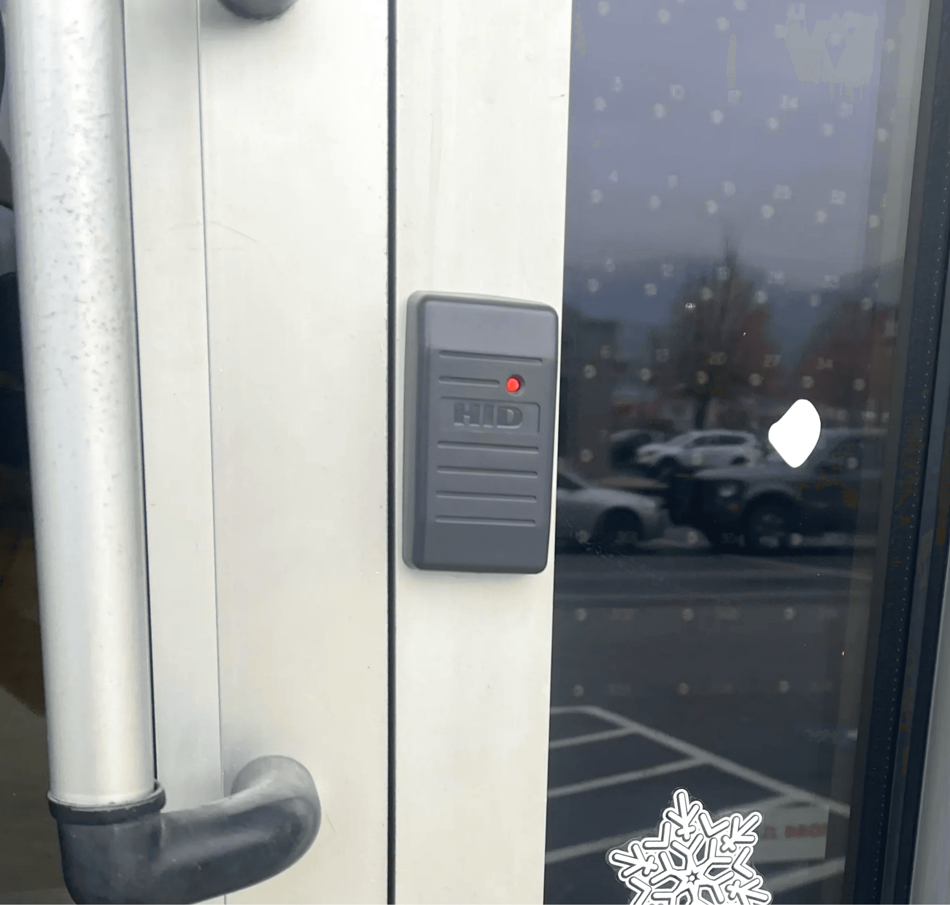 Access control system by Axe Fire & Security with secure card reader on a glass door entrance, featuring the company's logo, ensuring authorized entry for enhanced premises security in Central Washington.